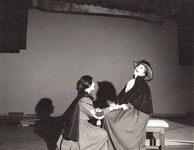 Scene from the University of Idaho drama production of "Cherry Orchard." This production was directed by Forrest Sears in the University Auditorium. One woman can be seen kneeling and holding the hands of another woman.