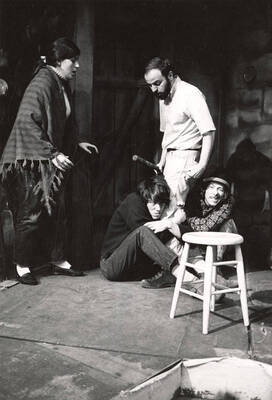 Scene from the University of Idaho drama production of "Playboy of the Western World." Two men can be seen holding the legs of another man, while a woman looks on. Directed by Forrest Sears in the U-Hut Experimental Theatre.