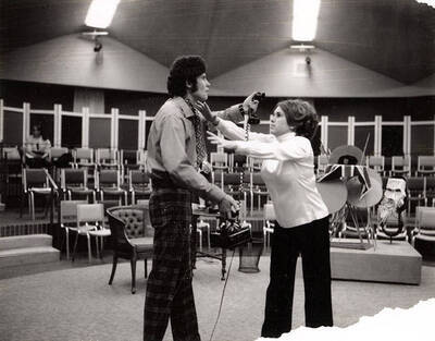 Scene from the University of Idaho rehearsal of "Black Comedy." One actor can be seen holding a phone, while another actor can be seen reaching for him. Directed by Forrest Sears for Summer Theatre in the Kiva.