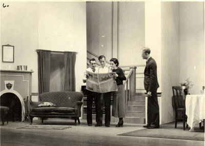 Scene from the University of Idaho drama production of "Three Cornered Moon." Three actors can be seen looking at a newspaper, while another man looks on. Cast members include Helen Wilson as Elizabeth Rimplegar, Erma Lewis as Mrs. Eimplegar, Aldrich Bowler as poet, Jean Ricker as Kitty, Burnell Baker as Dr. Stevens, and Catherine Bjornstad as Jenny. Directed by Fred Blanchard, Technical Director Theodore Prichard in the University Auditorium.