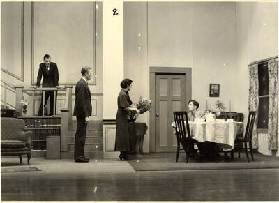 Group scene from the University of Idaho drama production of "Three Cornered Moon." Cast members include Helen Wilson as Elizabeth Rimplegar, Erma Lewis as Mrs. Eimplegar, Aldrich Bowler as poet, Jean Ricker as Kitty, Burnell Baker as Dr. Stevens, and Catherine Bjornstad as Jenny. Directed by Fred Blanchard, Technical Director Theodore Prichard in the University Auditorium.
