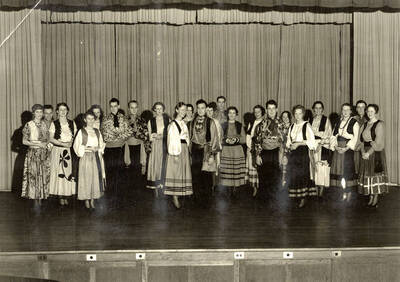 Group scene from the University of Idaho drama production of "The Gondoliers." The cast members can be seen dressed in costume and standing on stage.