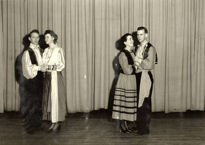 Group scene from the University of Idaho drama production of "The Gondoliers." The cast members can be seen dressed in costume and standing on stage. Pictured from left to right are Reginald Lyons, Dorothy Brown, Fay Pattijohn and Paul Rust.