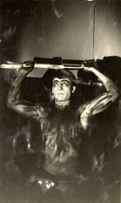 Scene during the University of Idaho drama production of "Hairy Ape." A man can be seen holding a prop above his head. Directed by Fred Blanchard, set by Theodore Prichard