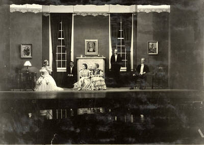 Scene from the University of Idaho drama production of "Trelawny of the Wells." Directed by Fred Blanchard, set by Theodore Prichard. In this scene, Miss Trafalgar Gower tells Miss Trelawny sneezing is 'quite out of place.' Members of the cast include Alberta Bergh Utt as Rose Trelawny, Robert Herrick as Tom Wrench, Marion Dresser as Imogen, Clarence Anderson as Colpoys, Jean Ricker as Avonia Bunn and Raphael Gibbs as Sir Gower.