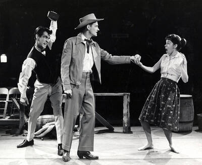 Scene from the University of Idaho drama production of "The Great Big Doorstep."  ASUI production directed by Jean Collette in the University Auditorium. One man can be seen handing something to a woman on stage.