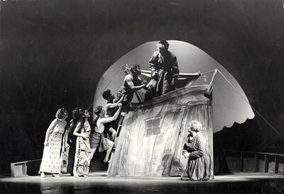 Scene from the University of Idaho drama production of "Noah." This production was directed by Jean Collette. The actors can be seen climbing onto the roof of the house on the set.