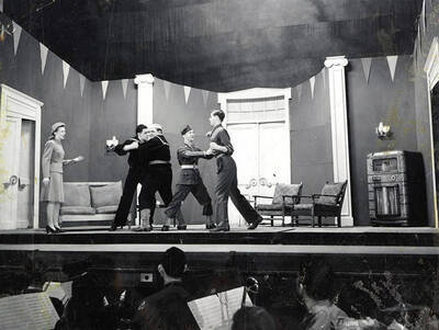 Scene from the ASUI production of "Gee-Eyes Right." Two men can be seen keeping two other men from fighting. Directed by Jean Collette, written Ted Sherman and Geoffrey Cope, music by Hall Macklin, costume advisor Marion Featherstone.