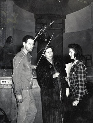 Scene from the ASUI production of "Gee-Eyes Right." Three cast members can be seen talking to each other. Directed by Jean Collette, written Ted Sherman and Geoffrey Cope, music by Hall Macklin, costume advisor Marion Featherstone.