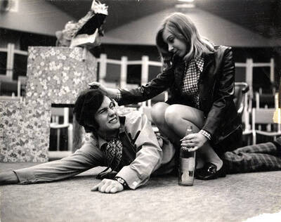 Scene from the Summer Theatre production of "Black Comedy." This production was directed by Forrest Sears in the Kiva. A woman can be seen sitting on top of a man.