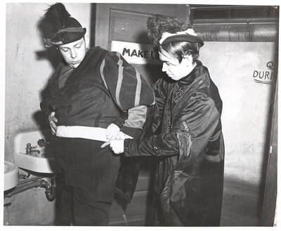Rich Pennell as Sir Toby Belch and Harry Dalva as Malvolio pause in the University Auditorium basement make-up room during the ASUI production of "Twelfth Night." Directed by Jean Collette in the University Auditorium, costumes by Marion Featherstone.