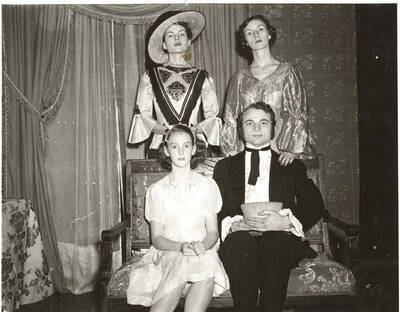 The ASUI production of "Uncle Tom's Cabin." Individuals identified as listed: Standing: Jo Anne Elam as Ophelia, Patricia Jordon as Marie St. Clare; seated: Nancy Buchanan as Eva and Maurice Paulsen as St. Clare. Directed and designed by Jean Collette in the University Auditorium.
