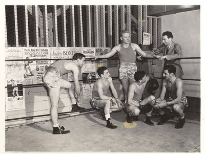 Idaho boxers talk and laugh with prominent Vandals head coach Louie August after a practice.