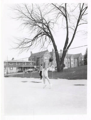 An unknown women's Tennis player practices her serves.