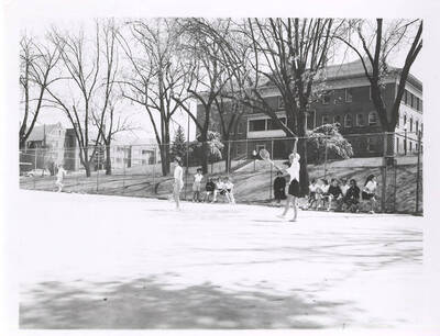 An unnamed women's Tennis player signals before a serve during a Tennis practice near Campus Drive.