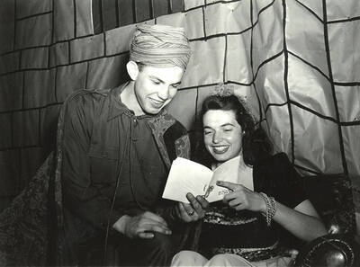 A couple reads through the program at the Phi Delta Theta Storybook Ball.