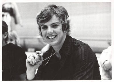 An unknown timekeeper smiles for a photograph at a meet in the Swim Center.