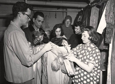 Clyde Winters, Mort Grinker, Jo Magee, Rex Hill, Doris Moore, Joan Coble  stand backstage in the costume section during a rehearsal of 'Hamlet.' Directed by Jean Collette, costumes by Joan Coble (Judy Chavez) in the University Auditorium.