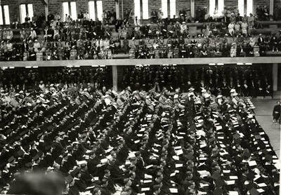 Graduates and audience sit in the Memorial Gym during the 1937 Commencement ceremony.