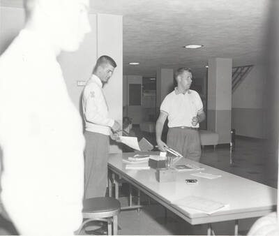 Members of the Intercollegiate Knights, a national honorary service organization, set up for a book sale fundraising event.