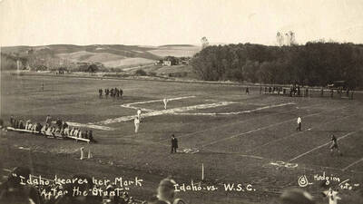 Yell Kings and Dukes participate in the Idaho Stunt for the Harvard Yell Contest during a football game. Caption reads: Idaho Leaves her Mark After the Stunt, Idaho vs. W.S.C. #8.