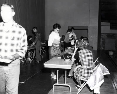 Students submit class cards and schedule cards to registrars during registration in the Memorial Gymnasium.