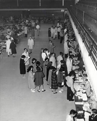Students wait in line to hand over schedule cards for course registration in the Memorial Gymnasium.