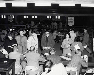 Students hand schedule cards to registrars in Memorial Gymnasium to register for second semester courses.
