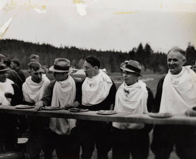 Faculty members, including Doc Martell, Professor Becraft, Professor Jahn, Professor Willeson, Dr. Ehrlich, and Dean Jeffers, participate in a pie-eating contest at the Associated Foresters barbeque.