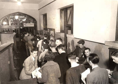 Students stand in line and discuss classes and schedules during registration in the Administration building.