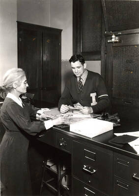 Earl Ritzheimer, paying his fees in the picture, became the first Idaho student with no. 2500 stamped on his registration form.
