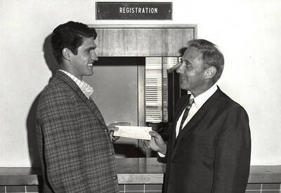 President Ernest W. Hartung congratulates Vernon K. Smith, Jr. on being the 6,185th student to register.