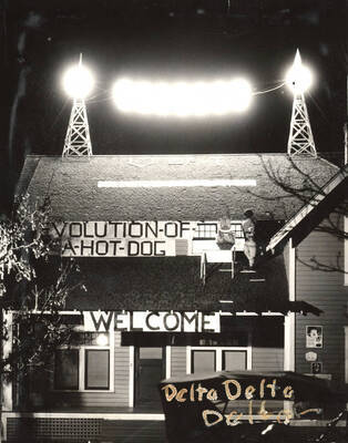 Delta Delta Delta house decorations feature a light display on the roof and a sign that reads 'Evolution of a hot dog, Welcome.'
