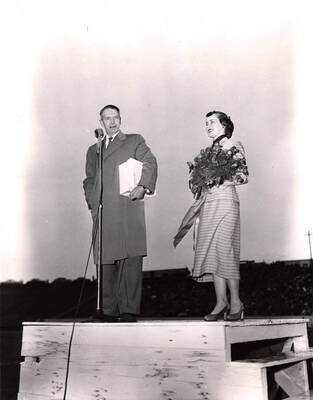 Governor Len Jordan and Homecoming Queen Leah Jensen stand before the crowd at the Idaho/WSC Homecoming game.