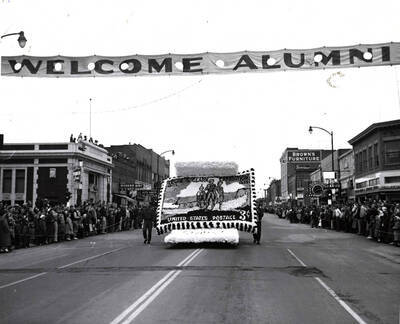 The Delta Tau Delta float in the Homecoming parade depicts a replica of the commemorative 'Lewis and Clark Expedition, 1805 - 1955' postage stamp.