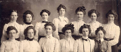 Beta Sigma charter members sitting for a portrait photograph. Back row, l-r: Jessie Gibson, Olive Regan, Zella Perkins, Mrs. Padelford, Emma Strong, Trula Keener, Daisy Booth; front row, l-r: Nell Ireton, Nina Wilkins, Mabel Martin, Edna Moore, Ruth Gipson, Della Brown