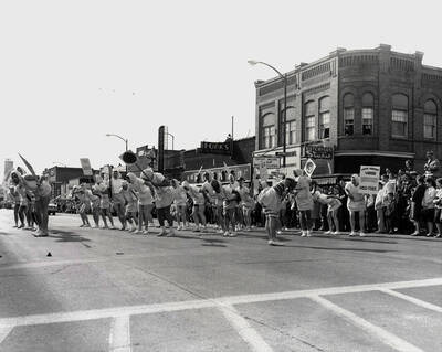 Kappa Sigma members participate in the Homecoming parade parodying as women wearing handkerchiefs and skirts.