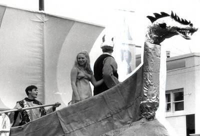 Pi Beta Phi and Phi Delta Theta members stand on their Viking themed float in the Homecoming parade.