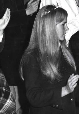 A photo of Sally Armstrong, Homecoming queen, waving during the football game.
