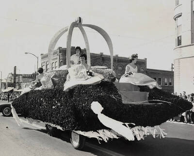 Peanuts-esque characters stand on top of an unassociated float in the Homecoming parade. The caption reads: 'Spartans are Smartin'.