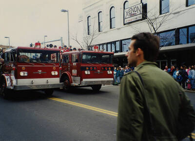 Student athletes ride in the back of fire trucks during the Homecoming parade.