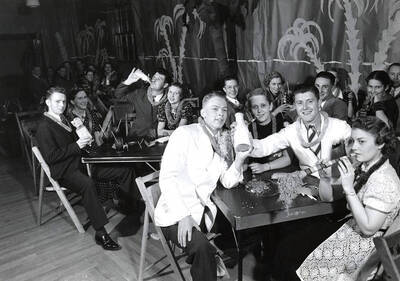Students sit at tables enjoying the tropical-themed Junior Week dance.