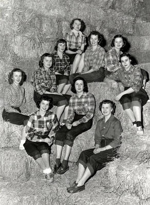 The contestants for Queen of Idaho's Little International Agriculture Show pose together atop hay bales.