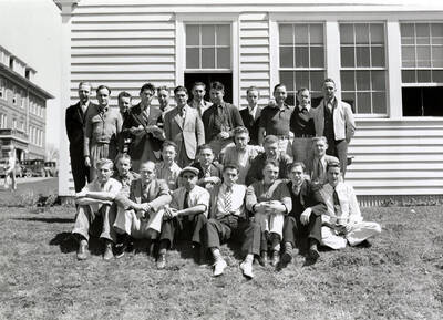 A group of men sit for a group photo by the side of a building during the judging of dairy products during the Little International Agriculture Show.
