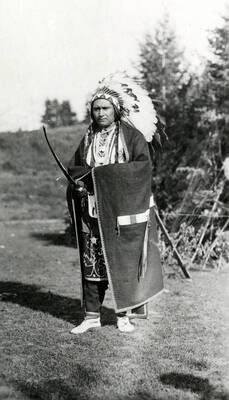 An unidentified man dressed as a traditional Native American chief poses holding a weapon for the Light on the Mountains pageant.