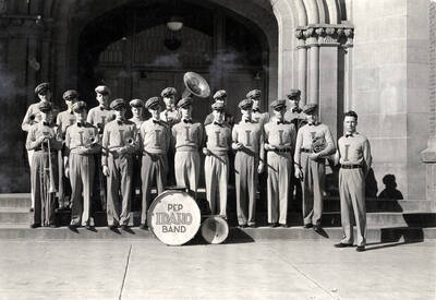 Idaho's pep band poses for a group photograph on the steps of the main entrance to the Administration Building. Students pictured: front row left to right: J. Wright, E. Pierce, P. Ennis, H. Reckord, W. Goss, J. Holt, C. Spear, J. Snodgrass, R. Thompson, R. Campbell; back row left to right: J. Armour, J. Gray, B. Seymour, d. Swingler, H. Nelson, S. Ryan, R. Radford, A. Blair.