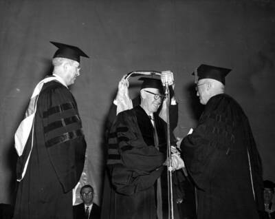 Judge William Healy is hooded and receives an honorary Doctorate of Law degree. Dean Stimson and President Donald R. Theophilus congratulate Healy.