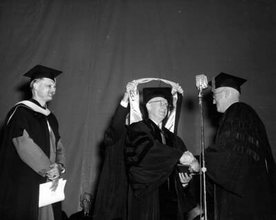 Dean Janssen and President Theophilus congratulate Mark Kulp for earning an honorary doctorate in science as he is hooded.