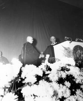 John David Remsberg Jr., president of the Board of Regents, shakes hands with Donald R. Theophilus after formally proclaiming him as the President of the University of Idaho.