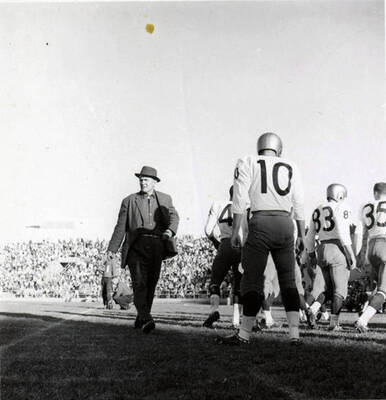 The coach walks back to the sidelines as the players walk onto the field during the Idaho vs. Washington State football game at the University of Idaho.